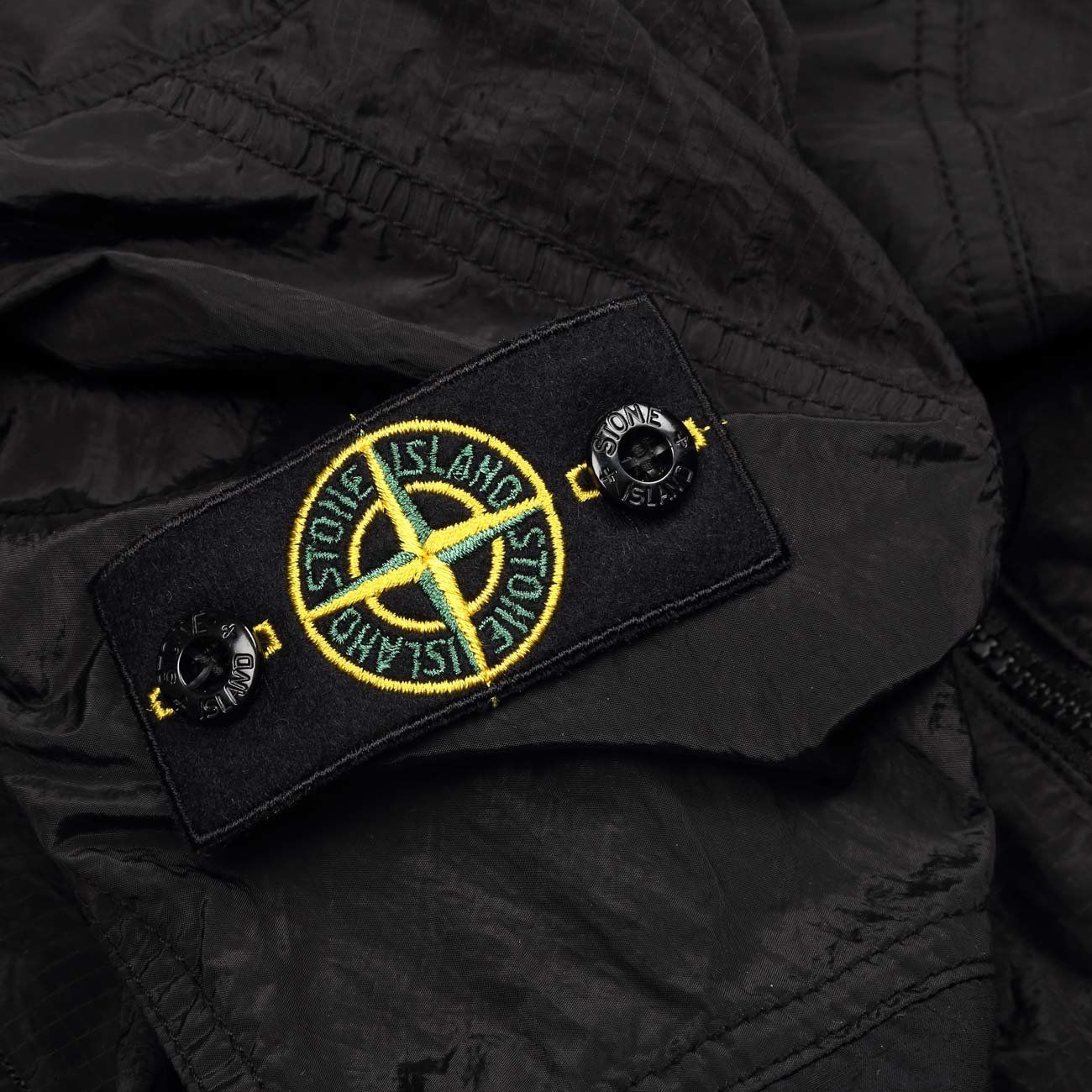 stone island badge on left arm